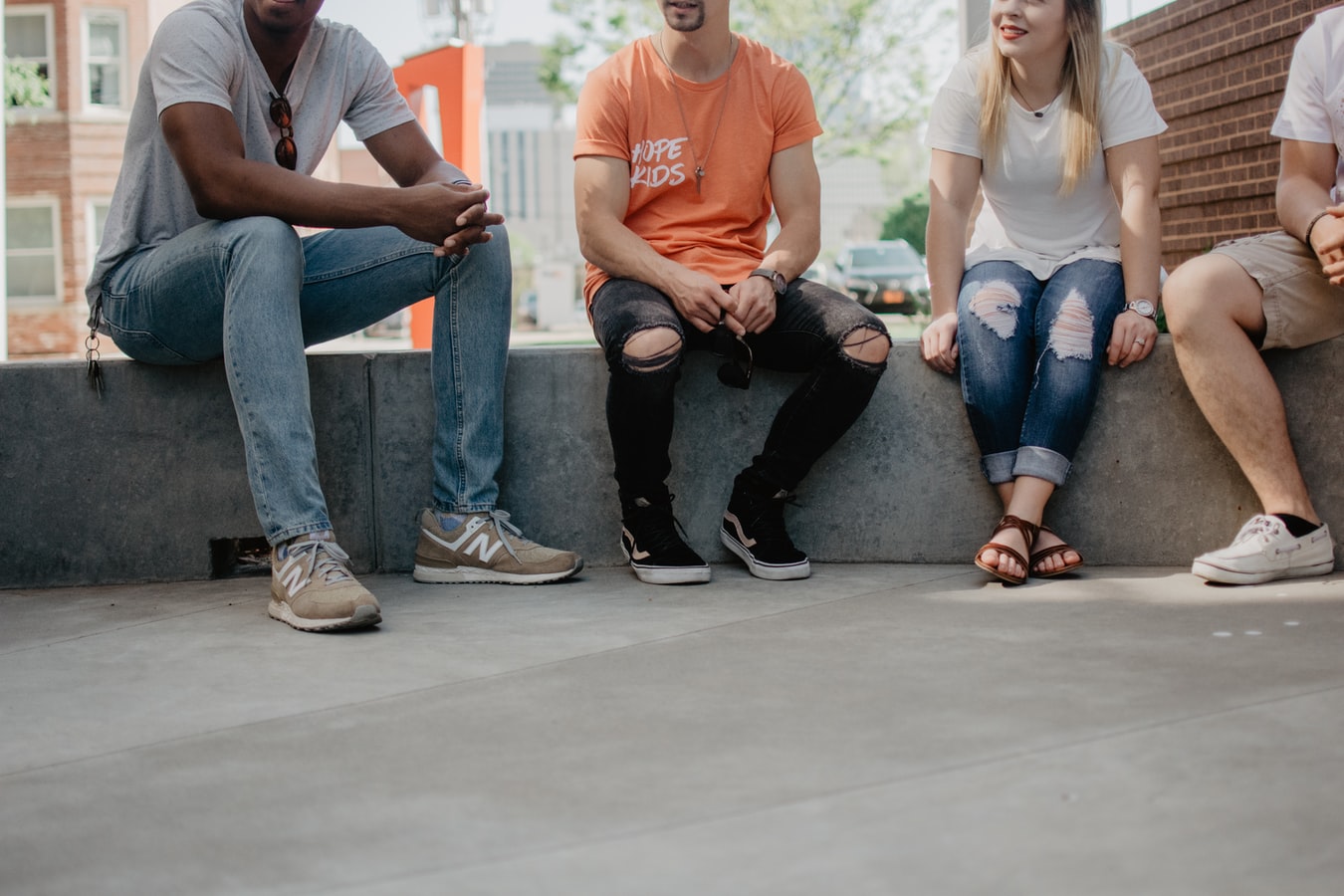 Four people sitting on a concrete bench